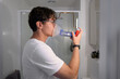 © Rowena Naylor/Stocksy - Person using a nebulizer in a bathroom during medication time