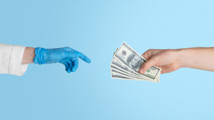 Unrecognizable patient giving money to doctor in rubber glove, close up of hands