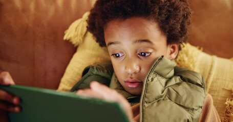 Poster - Gaming, learning and tablet with black child on sofa in living room of home for education or development. Relax, study and technology with African boy in apartment for online challenge or game