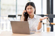 © David - Smile Young business Asian woman freelancer is working her job on a laptop computer and call phone. Doing accounting analysis report real estate investment data, Financial and tax systems concept.