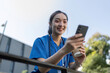 © Natee Meepian - Young Asian Female Nurse Enjoying a Break Outdoors with Phone
