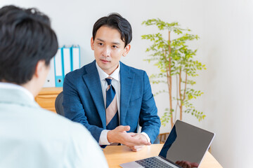 真剣な表情で商談をするスーツを着た男性