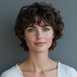 © Руслан Галиуллин - minimalistic portrait of caucasian woman 40 years old with short curly hair on grey background