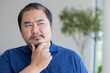© 9nong - Serious, Pensive, thoughtful middel aged Asian man thinking, planning, finding a good plan, idea, solution