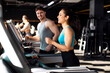 © Home-stock - Athletic young people jogging on treadmills in gym, man and woman running, exercising together