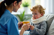 © lizavetta - Asian female doctor in medical gown giving hot drink in mug to sick little curly boy.
