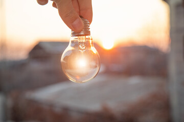 Wall Mural - Man holding a light bulb. Creative new idea