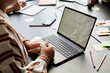 © Seventyfour - Cropped shot of woman studying in group class sitting at desk with open laptop displaying white blank screen in language school for adult learners, copy space