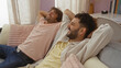 © Krakenimages.com - Two men relaxing on a couch in a cozy living room, enjoying a moment of laughter and friendship together indoors