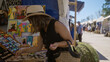 © Krakenimages.com - Woman browsing colorful artwork at outdoor market in palma mallorca spain on a sunny day