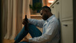 © Yuliia - Sad upset African American man drunk male addicted guy alcohol addiction drinking beer alone at home kitchen evening on floor suffer heartbreak divorce health problem alcoholism bankruptcy loan lost
