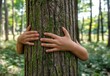 © ANUAR - Close-up of Child's Hands Gently Embracing a Tree Trunk Surrounded by Lush Green Forest, Symbolizing Nature Connection and Environmental Awareness