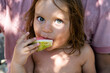 © Alisa Chikov - Portrait of a cute baby. The kid eats a watermelon and looks at the camera . Lifestyle. Candid. The concept of an active family holiday. Selective focus. Front view. Close-up.