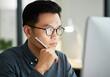 © Running opossum - Asian businessman holding pen and focusing on computer screen while working in modern office