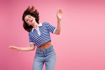 Wall Mural - Charming young woman with brunette bob dancing joyfully in trendy knitwear against a vibrant pink background