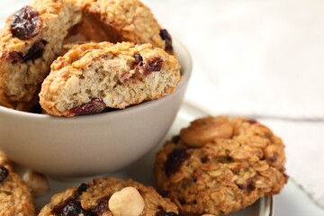 Delicious oatmeal cookies with raisins and nuts on table, closeup