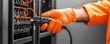 © Daylife - Battery replacement, Charging. A worker connects cables in a control panel with orange gloves.