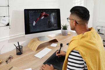Fototapete - Professional retoucher working on graphic tablet at desk in office