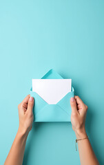 Poster - Hands grasping a blue envelope and white card in front of an empty, pastel blue space devoid of distraction or clutter._00001_