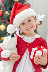 Portrait of little cute girl in  Santa Claus costume  with Christmas present