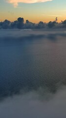 Wall Mural - aerial view of bright clouds over sea in bright sunset colors. vertical video