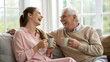 © HUMAN STUDIO - Heartwarming Moments: A Grandfather and Granddaughter Sharing Joyful Laughter Over Coffee in Their Cozy Living Room