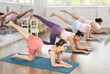 © JackF - Women on hands and knees doing stretch exercises for legs with expander on mats