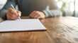 © oksa_studio - Accountant writing on a blank notebook page at wooden desk