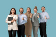 © Pixel-Shot - Team of technical support agents showing thumbs-up on blue background