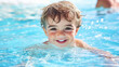 © Tipakorn - cheerful little boy enjoys swimming in bright blue pool