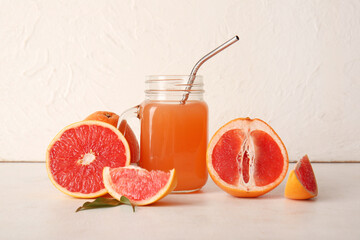 Wall Mural - Mason jar with tasty grapefruit juice and fresh fruits on light background