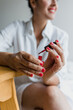 © Marcos - Latin adult woman painting finger nails at home in Mexico Latin America, Hispanic brunette people