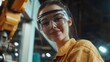 © Johannes - young female worker smiling confident wearing safety goggles using robotic arm at factory