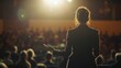 © Endin - Woman speaker presenting to large audience on stage.