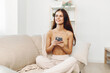 © SHOTPRIME STUDIO - Happy Woman Relaxing on Sofa, Holding Mobile Phone, Enjoying Online Games and Chatting in Cozy Living Room
