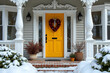 © Nyetock - Entrance of pretty vintage house with ornate columns on porch and red valentine wreath on bright yellow door in snow.