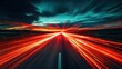 © Andini - Dramatic sunset over a long highway with fast car light trails.