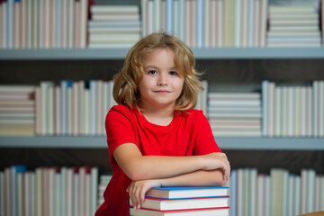 Fototapete - Smart pupil. Child reading book in a book store or school library.