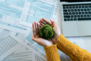 Wall Mural - Human hands holding a green globe for Earth Day, Green energy, ESG concept, Sustainable renewable resources, Tax, Law, Environmental care