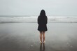 © Yuliya - Solitude by the Sea: A woman stands alone on a misty beach, facing the vast ocean, her silhouette a poignant symbol of contemplation and introspection.