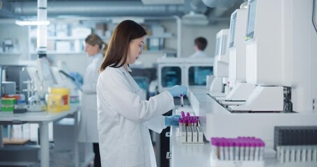 Aufkleber - In a Bright and Sterile Hospital Lab, a Young Asian Scientist Carefully Prepares Test Vials for Genetic Analysis as Her Male and Female Colleagues Prepare Medical Equipment in the Background