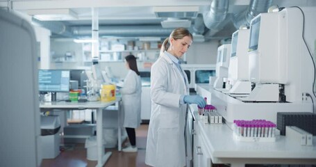 Aufkleber - Biomedical Researchers Conduct Experiments in a Modern Laboratory. Female Scientist Preparing a Set of Samples in Test Tubes with Purple Caps. Colleague Analyzes Data on a Computer in the Background