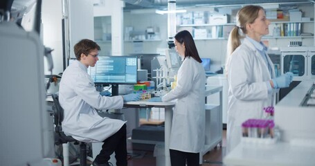 Aufkleber - Biomedical Researchers Conduct Experiments in a Modern Hospital Laboratory. Asian Female Scientist Bringing a Set of Samples in Test Tubes to a Male Colleague with a Desktop Computer