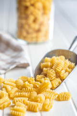 Wall Mural - Uncooked italian pasta. Radiatori pasta in scoop on white table.