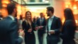 © Minijus - A softly blurred networking event featuring business professionals in formal attire, mingling and conversing in a modern venue with warm lighting, creating a vibrant yet professional atmosphere