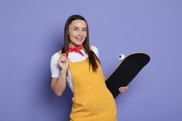 Wall Mural - Smiling woman with skateboard on violet background