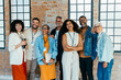 © (JLco) Julia Amaral - Diverse and happy small business team posing together in a sleek and modern office environment