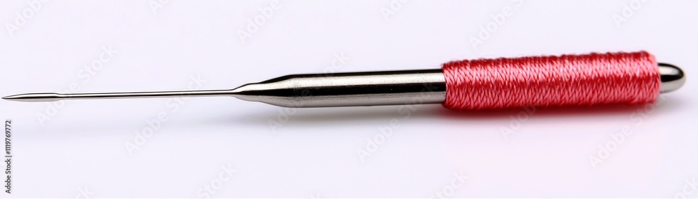 Metallic sewing needle with red thread wrapped around the handle on a ...