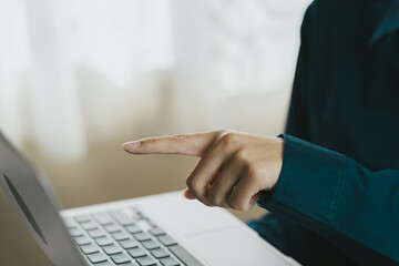 Poster - person pointing at laptop screen, engaged in digital task, showcasing focus and interaction. soft background adds calm atmosphere to scene