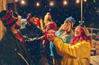 © Lustre Art Group  - Lively outdoor holiday party with friends in ski gear toasting with red cups and mugs, surrounded by snow and seasonal decorations. Concept of holidays, Christmas party. Ad